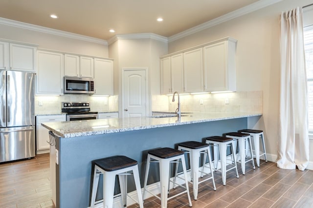 kitchen with stainless steel appliances, white cabinetry, and sink