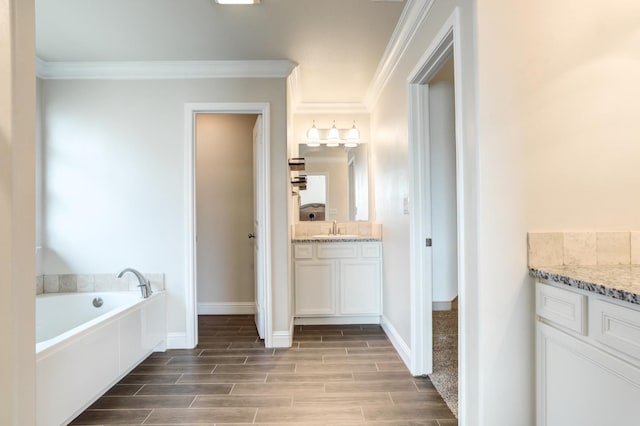 bathroom featuring vanity, ornamental molding, and a tub to relax in