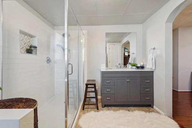 bathroom featuring vanity, hardwood / wood-style floors, a drop ceiling, and walk in shower