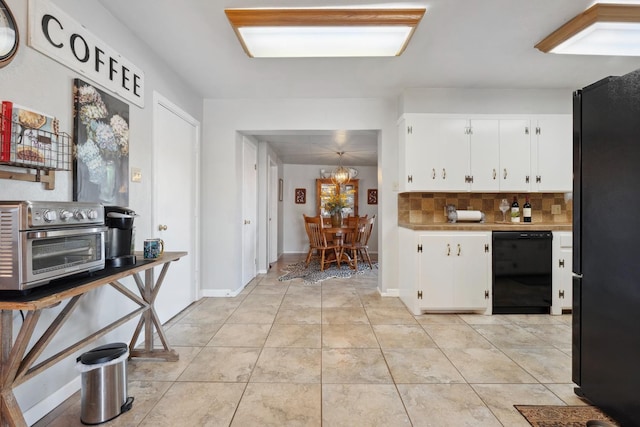 kitchen with tasteful backsplash, light tile patterned floors, white cabinets, and black appliances