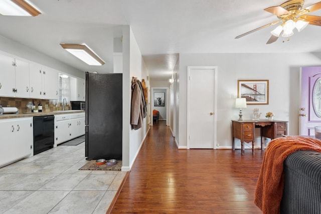 kitchen featuring sink, white cabinetry, tasteful backsplash, light hardwood / wood-style flooring, and black appliances