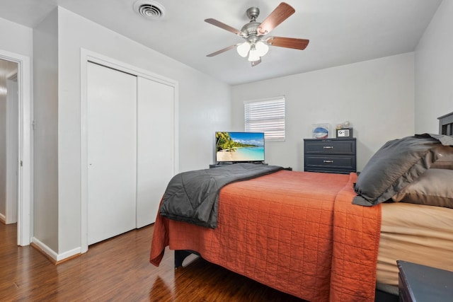 bedroom featuring dark hardwood / wood-style floors, ceiling fan, and a closet