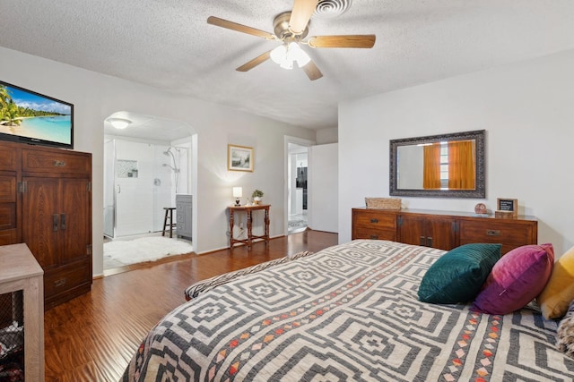 bedroom featuring ceiling fan, hardwood / wood-style floors, and a textured ceiling