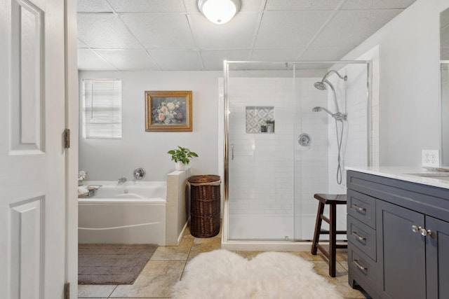 bathroom featuring vanity, tile patterned flooring, shower with separate bathtub, and a drop ceiling