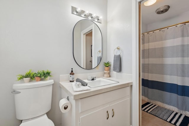 bathroom featuring vanity, curtained shower, tile patterned floors, and toilet