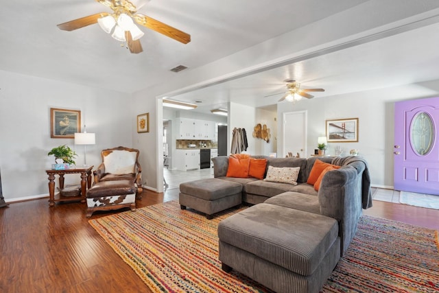 living room featuring ceiling fan and dark hardwood / wood-style flooring