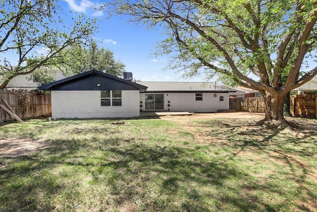 back of house featuring a patio, a yard, fence, and brick siding