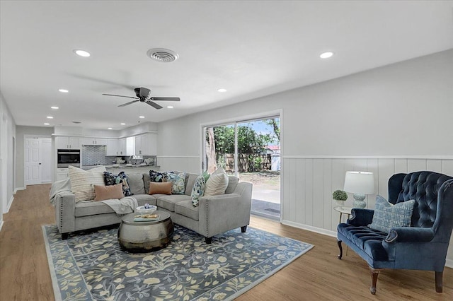 living room with ceiling fan and light hardwood / wood-style flooring