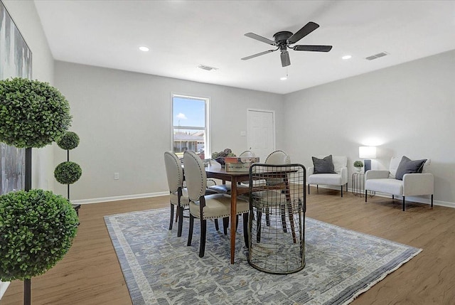 dining area featuring a ceiling fan, wood finished floors, visible vents, and baseboards