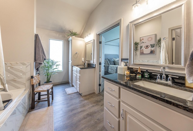 10323 Ave X, Lubbock, TX 79423 - full bath featuring lofted ceiling, wood finished floors, two vanities, and tiled tub