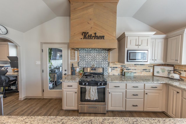 10323 Ave X, Lubbock, TX 79423 - kitchen with appliances with stainless steel finishes, vaulted ceiling, dark wood-type flooring, light stone counters, and tasteful backsplash
