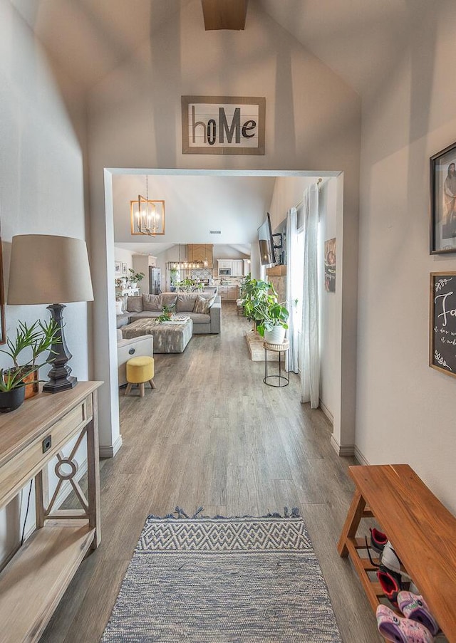 10323 Ave X, Lubbock, TX 79423 - hallway with high vaulted ceiling, a chandelier, and wood finished floors