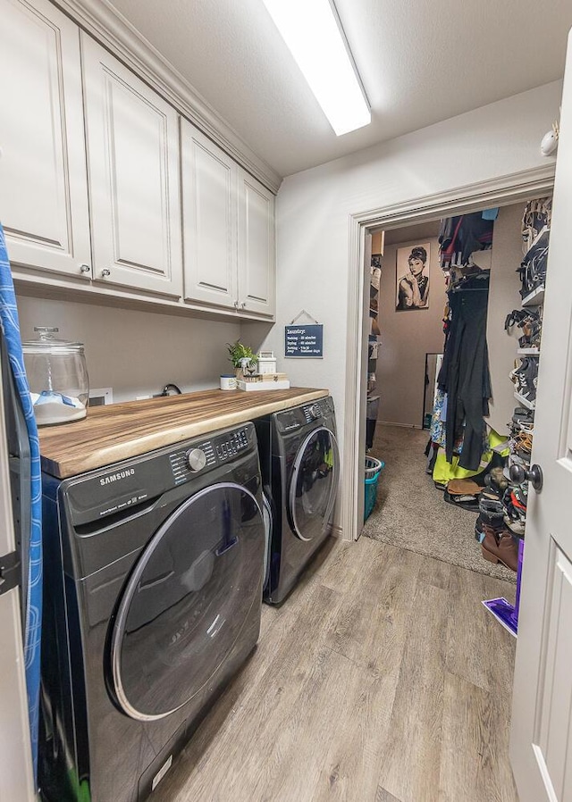 10323 Ave X, Lubbock, TX 79423 - laundry room with washing machine and dryer, cabinet space, and light wood-style floors