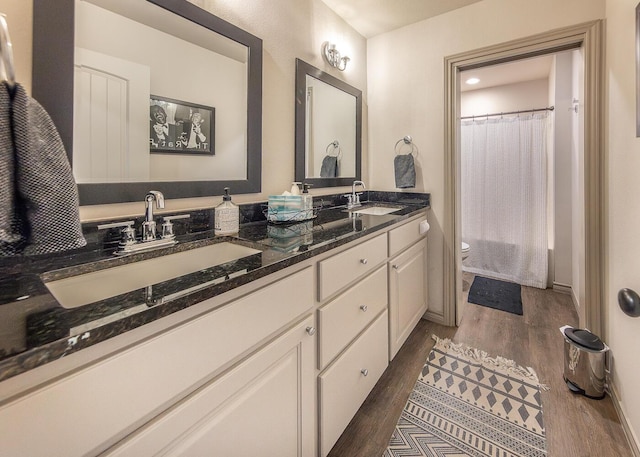 10323 Ave X, Lubbock, TX 79423 - bathroom featuring wood finished floors, double vanity, and a shower with curtain