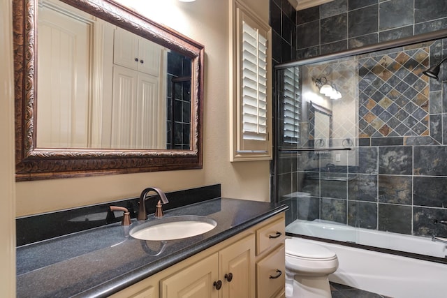 bathroom featuring toilet, vanity, and shower / bath combination with glass door