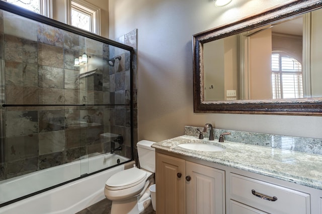 full bathroom featuring shower / bath combination with glass door, a wealth of natural light, toilet, and vanity