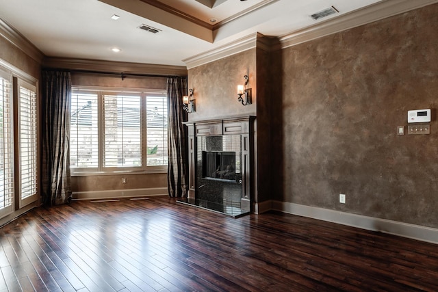 unfurnished living room featuring hardwood / wood-style floors, visible vents, baseboards, and ornamental molding