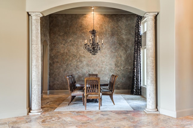 dining area featuring arched walkways, stone finish floor, baseboards, and ornate columns