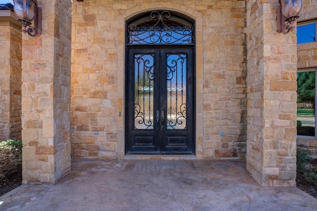 view of exterior entry with french doors and stone siding