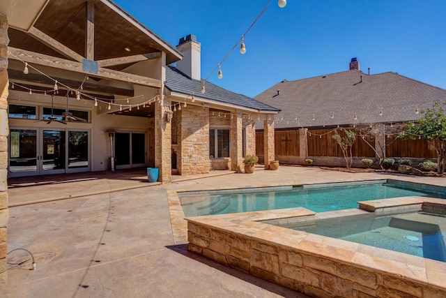 view of pool featuring a ceiling fan, a pool with connected hot tub, a patio, and a fenced backyard