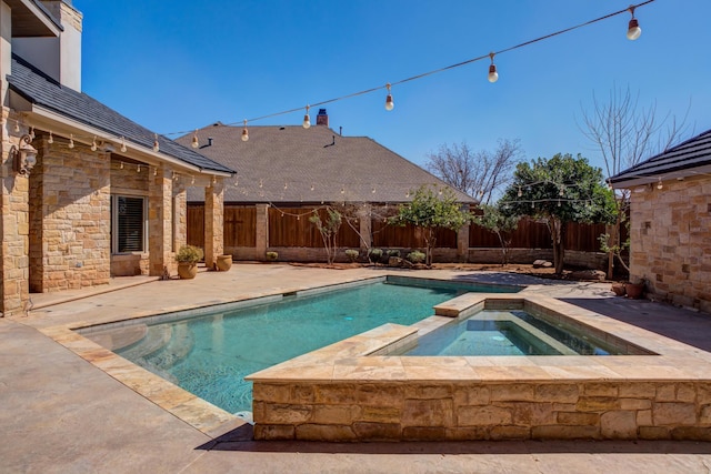 view of swimming pool with a patio area, a pool with connected hot tub, and a fenced backyard