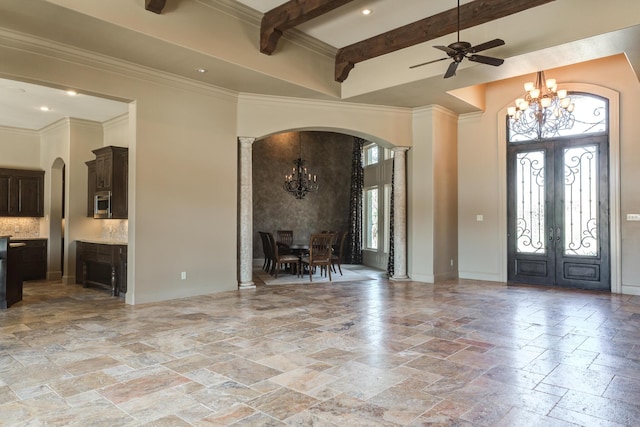 foyer featuring arched walkways, stone tile floors, a towering ceiling, and french doors