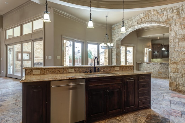 kitchen with stainless steel dishwasher, a sink, stone tile floors, arched walkways, and ornamental molding