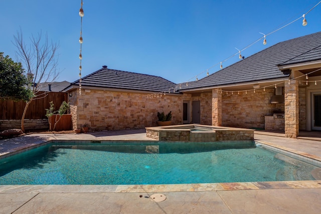 view of pool featuring fence, a patio area, and a pool with connected hot tub