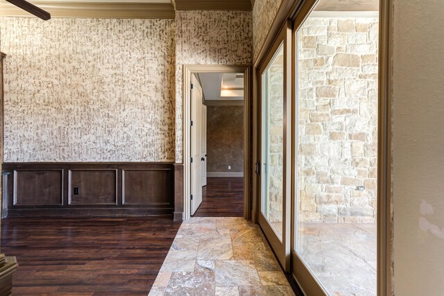corridor featuring dark wood-type flooring and ornamental molding