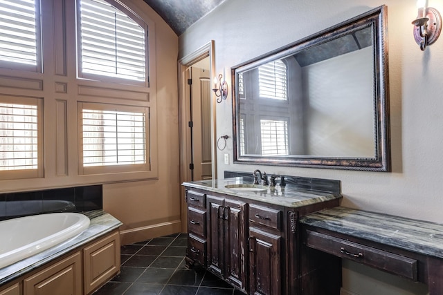 bathroom with a bath, baseboards, vanity, and tile patterned floors