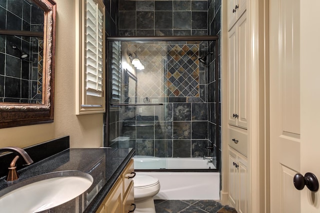 bathroom with shower / bath combination with glass door, toilet, and vanity