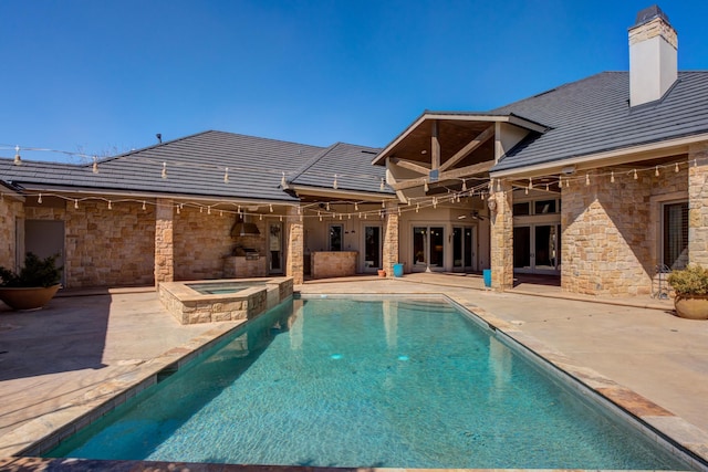view of swimming pool featuring a patio area, a ceiling fan, french doors, and a pool with connected hot tub