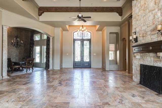 foyer with arched walkways, stone tile flooring, french doors, and a healthy amount of sunlight