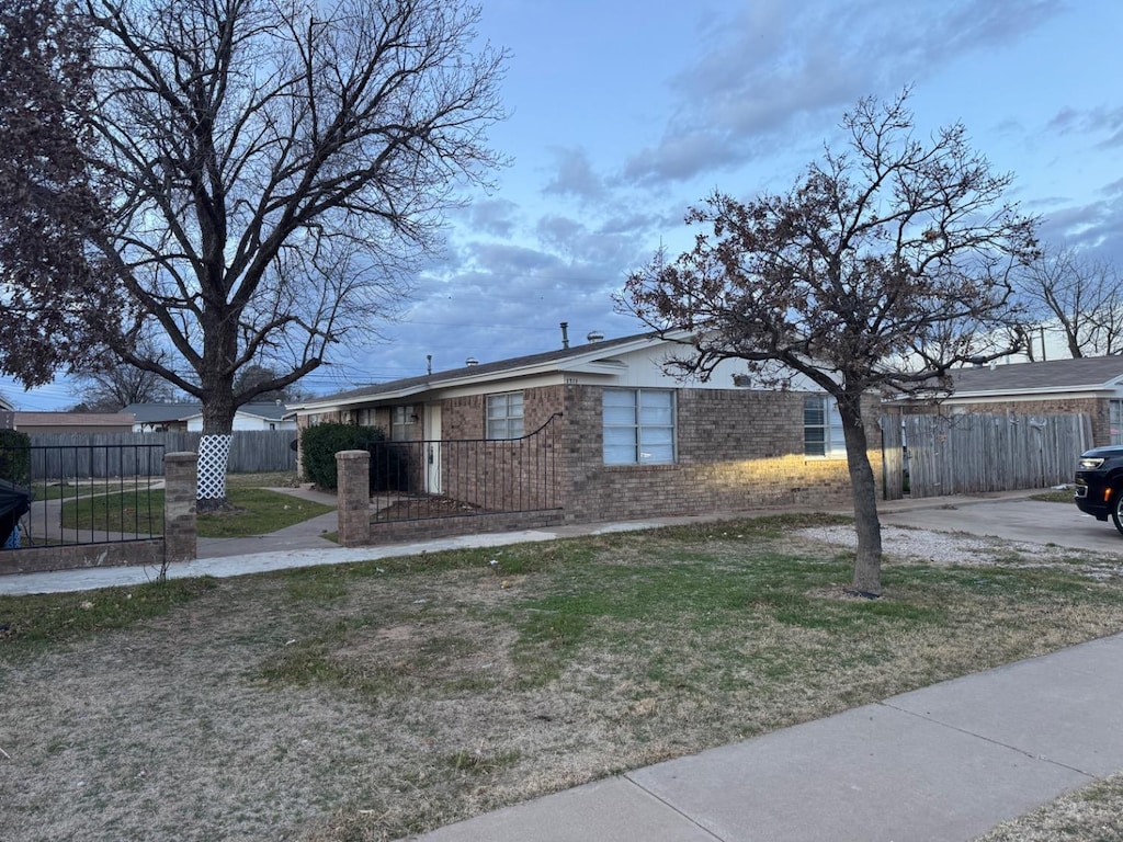 single story home featuring a front lawn