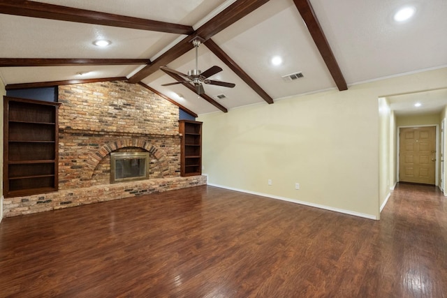 unfurnished living room featuring a fireplace, vaulted ceiling with beams, dark hardwood / wood-style flooring, ceiling fan, and built in shelves