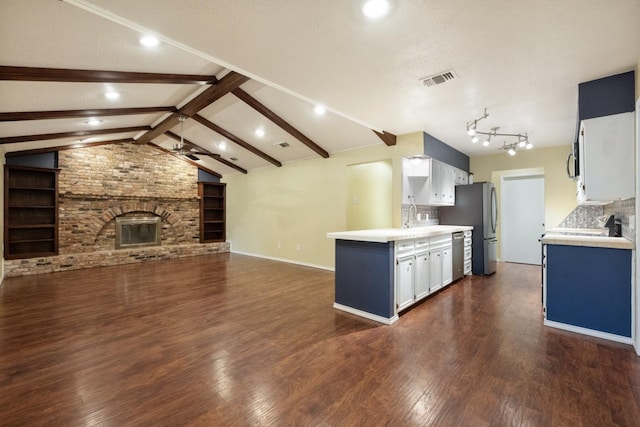 kitchen featuring white cabinetry, dishwasher, vaulted ceiling with beams, dark hardwood / wood-style flooring, and a brick fireplace