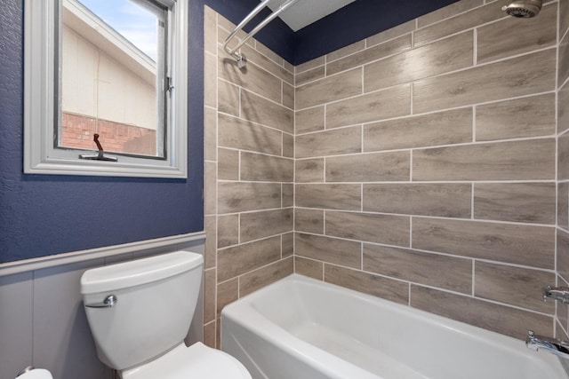 bathroom with toilet and tiled shower / bath combo