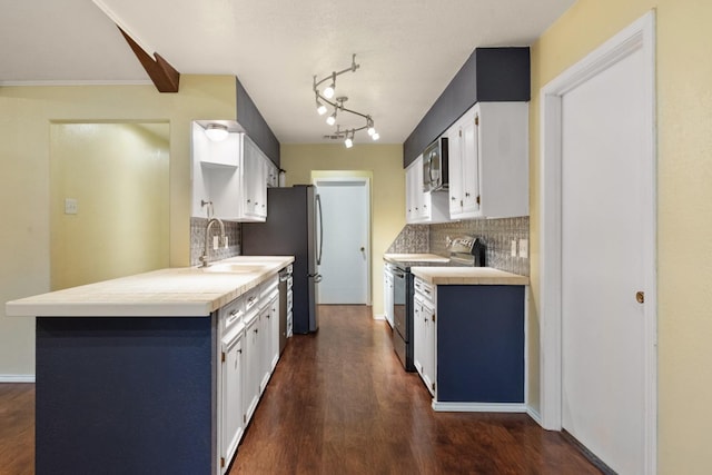 kitchen with sink, white cabinetry, tasteful backsplash, appliances with stainless steel finishes, and dark hardwood / wood-style floors