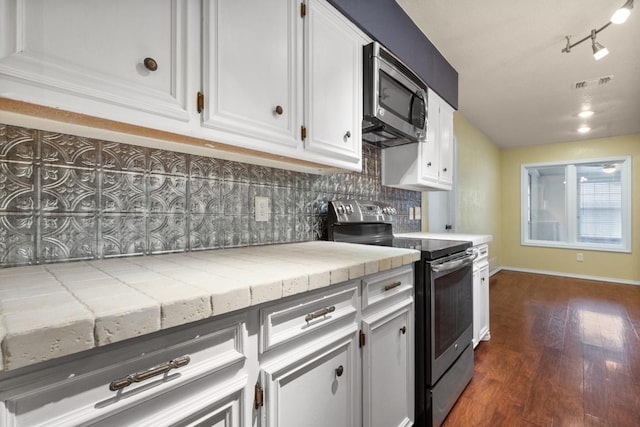 kitchen featuring appliances with stainless steel finishes, tile countertops, decorative backsplash, and white cabinets