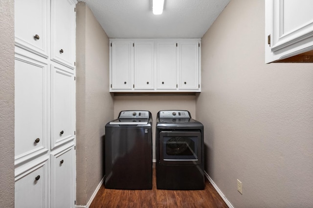 clothes washing area with dark hardwood / wood-style flooring, a textured ceiling, cabinets, and washing machine and clothes dryer