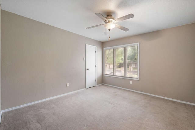 carpeted empty room featuring a textured ceiling and ceiling fan