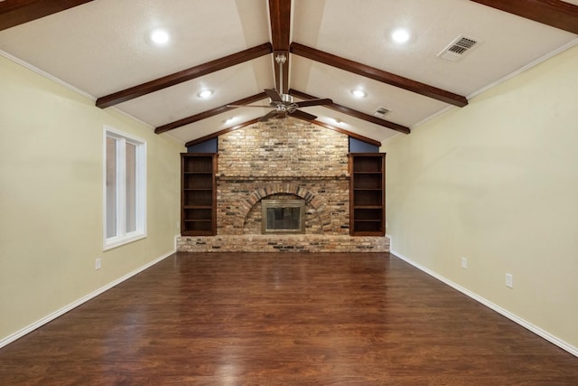 unfurnished living room with built in shelves, lofted ceiling with beams, a brick fireplace, dark hardwood / wood-style floors, and ceiling fan