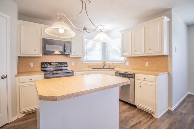 kitchen featuring pendant lighting, sink, a center island, black appliances, and dark wood-type flooring