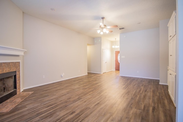 unfurnished living room with a tile fireplace, lofted ceiling, ceiling fan, and dark hardwood / wood-style flooring