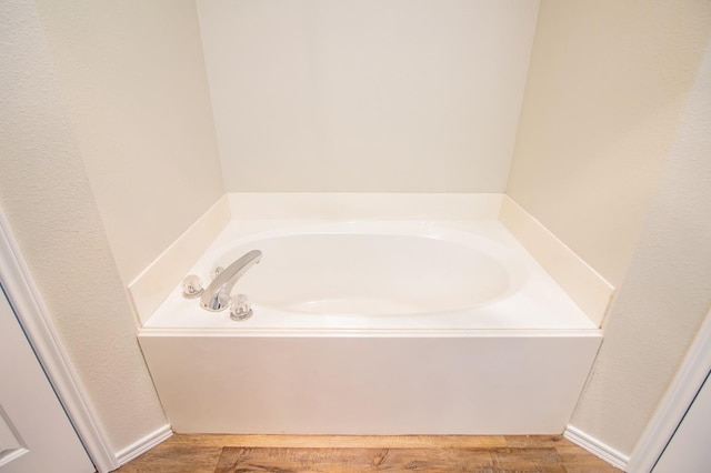 bathroom featuring wood-type flooring and a bathing tub