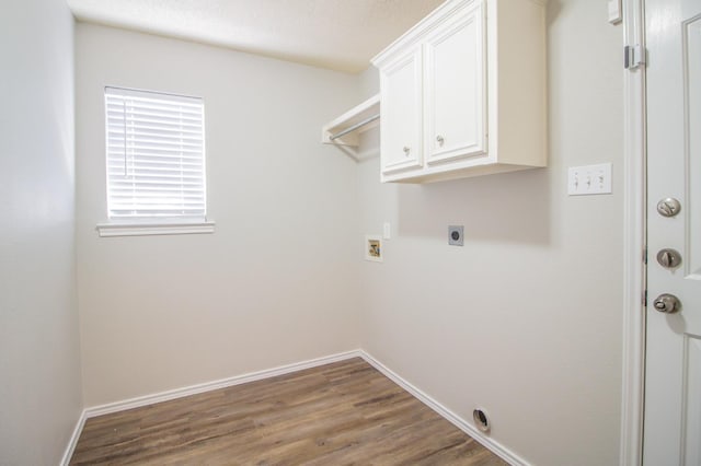 washroom with hardwood / wood-style floors, electric dryer hookup, washer hookup, and cabinets