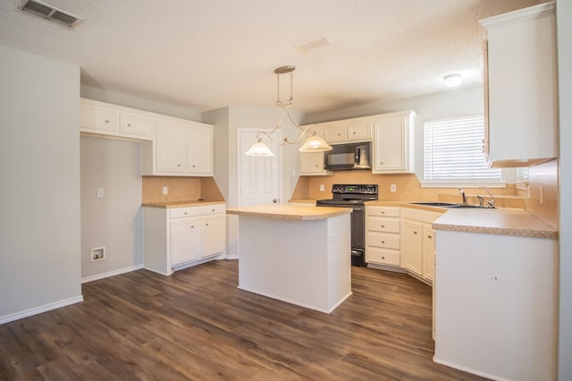 kitchen featuring a kitchen island, pendant lighting, white cabinets, and black appliances