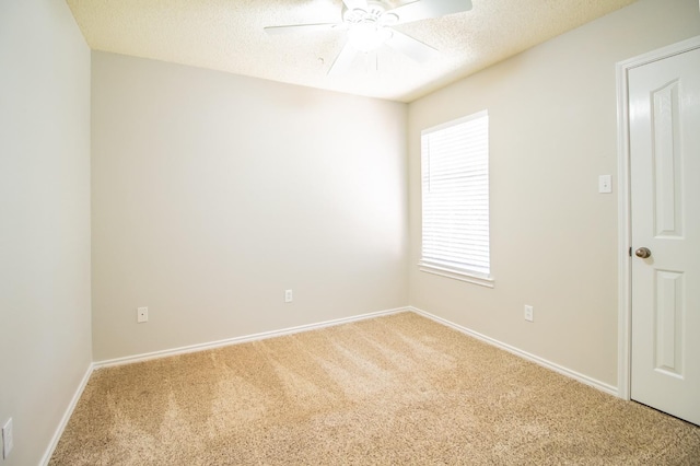 empty room with ceiling fan, carpet flooring, and a textured ceiling