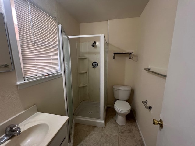 bathroom featuring vanity, tile patterned floors, a shower with door, and toilet