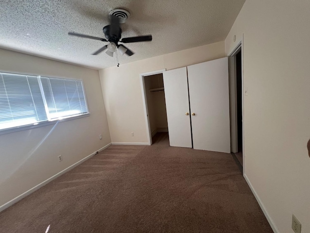 unfurnished bedroom featuring ceiling fan, carpet flooring, a textured ceiling, and a closet